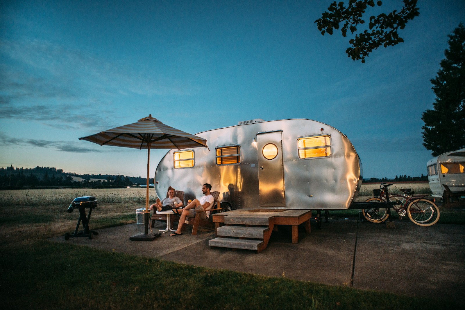 Couple détendu près de leur caravane Airstream sur terrain de camping au Québec — Soumission assurance VR